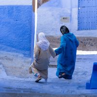 Dos mujeres bajan una calle estrecha en la ciudad azul de Chefchaouen – Jake Cushnir (EEUU)
